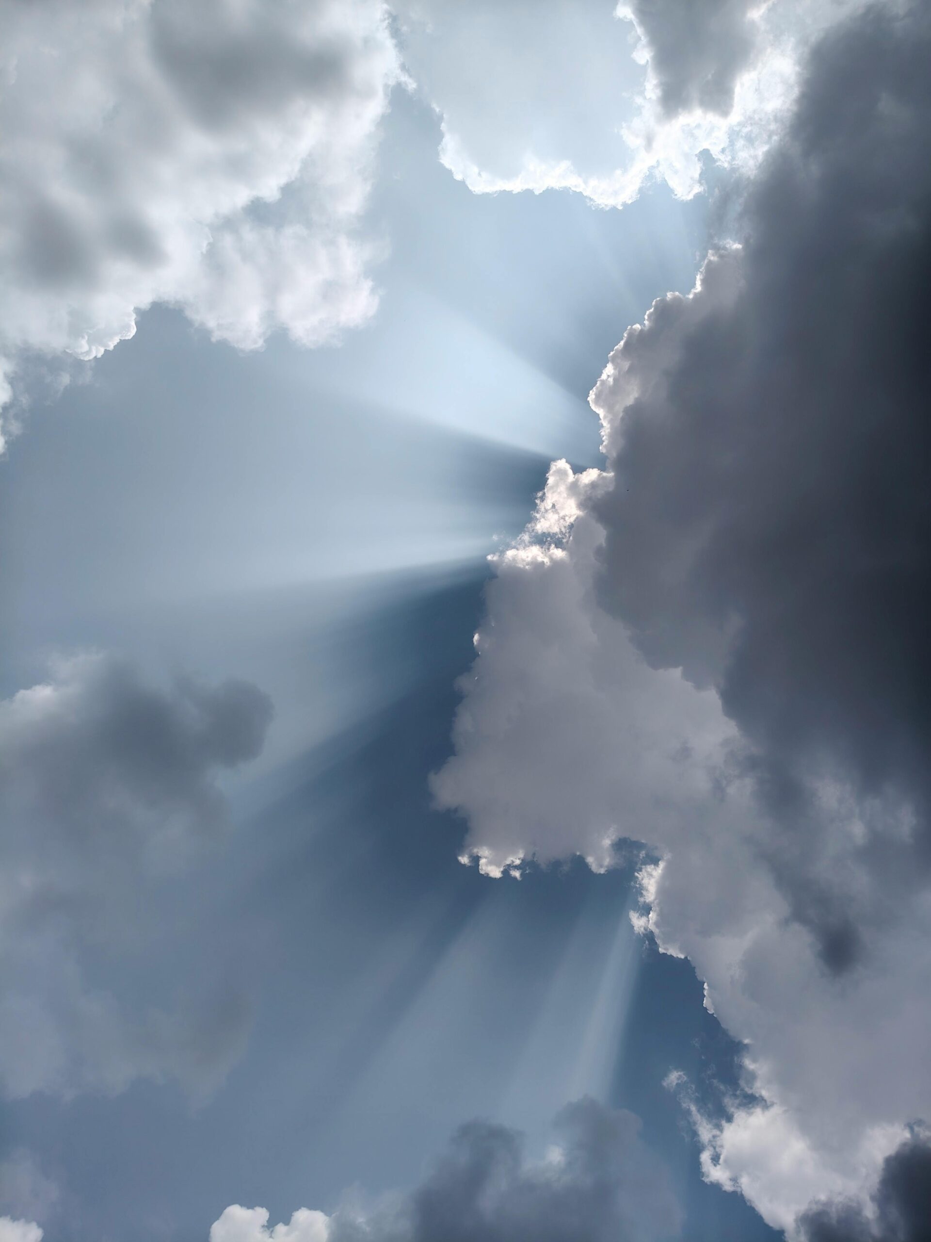 Captivating view of sunlight streaming through dramatic clouds in a serene sky.