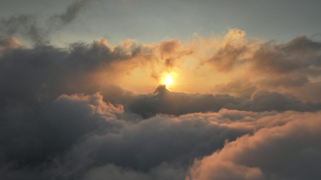 Experience a breathtaking sunset above the clouds with vibrant colors and ethereal beauty.